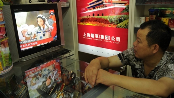 A shopowner in Shanghai watches as China's first female astronaut returns to Earth