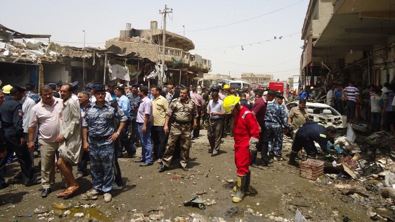 Iraqi rescue personnel examine the scene in Diwaniya following this morning's blast