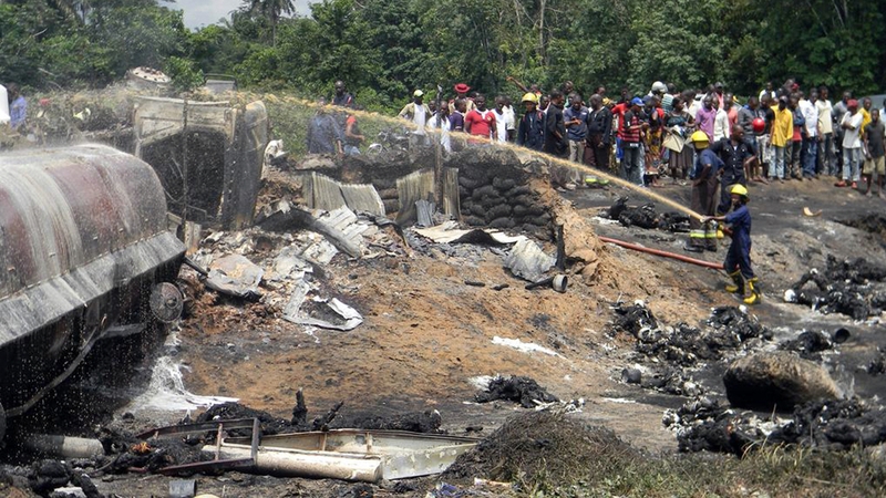 A fireman sprays water on the wreckage of the tanker