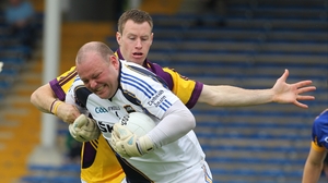 Tipperary goalkeeper Paul Fitzgerald bursts through the tackle of Wexford's Paddy Byrne