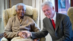 Former US president Bill Clinton poses with Nelson Mandela on the eve of his 94th birthday in 2012