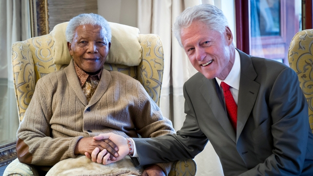Former US president Bill Clinton poses with Nelson Mandela on the eve of his 94th birthday in 2012