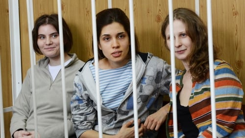 Members of the all-girl punk band 'Pussy Riot' Nadezhda Tolokonnikova (C), Maria Alyokhina (R) and Yekaterina Samutsevich (L), sit behind bars