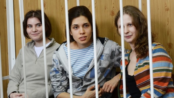 Members of the all-girl punk band 'Pussy Riot' Nadezhda Tolokonnikova (C), Maria Alyokhina (R) and Yekaterina Samutsevich (L), sit behind bars