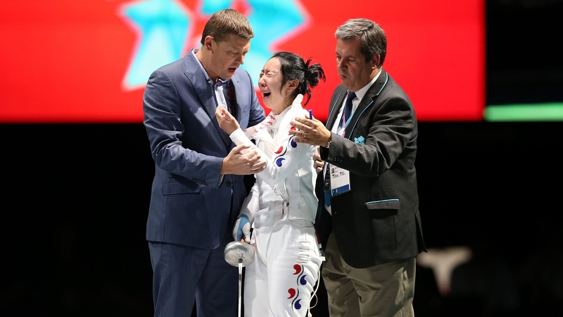 Shin A Lam is encouraged to leave the piste after her controversial loss