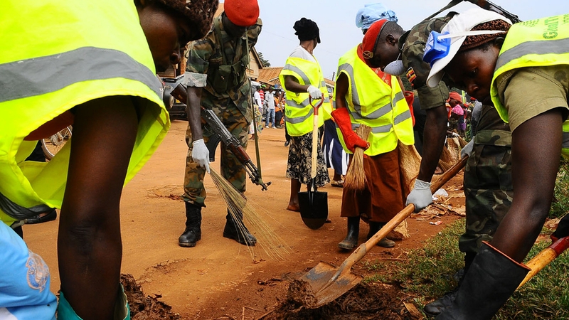 Ugandan Military Police officers help in collecting garbage at Makindye Division, a Kampala suburb during a cleaning exercise
