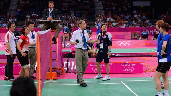 An official threatens Greysia Polii and Meiliana Jauhari of Indonesia and Jung Eun Ha and Min Jung Kim of Korea with a 'black card' disqualification