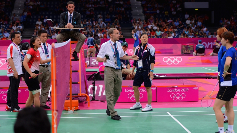 An official threatens Greysia Polii and Meiliana Jauhari of Indonesia and Jung Eun Ha and Min Jung Kim of Korea with a 'black card' disqualification