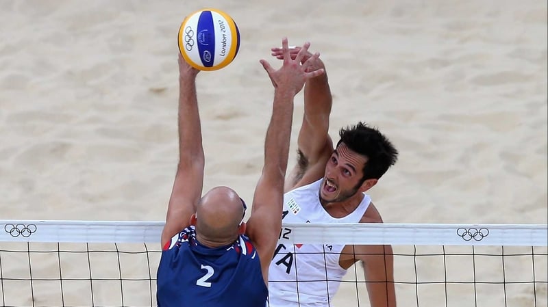 Phil Dalhausser of the United States blocks the shot of Italy's Paolo Nicolai