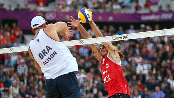 Alison Cerutti of Brazil hits a return against against Poland's Mariusz Prudel