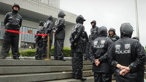 Police stand guard the outside the Intermediate People's Court in Hefei