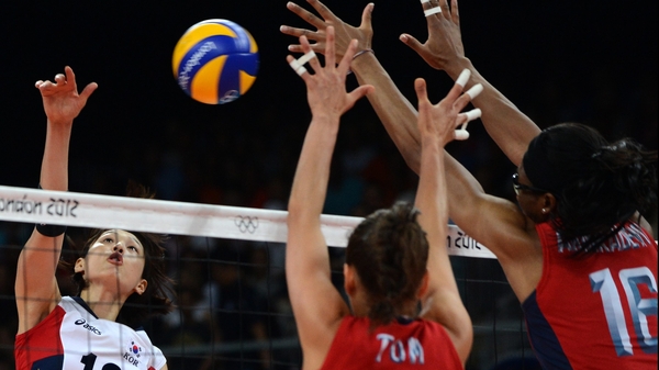 South Korea's Kim Yeon-Koung (L) spikes as Logan Tom (C) and Foluke Akinradewo of the US attempt to block
