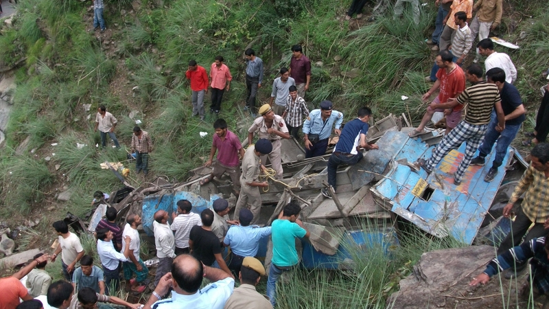 Onlookers and rescuers at the scene of a bus crash in northern India