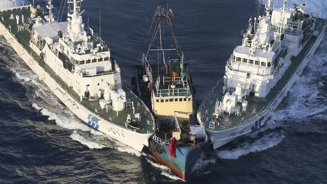A boat is surrounded by the Japanese coast guard near a group of islands disputed by Japan and China