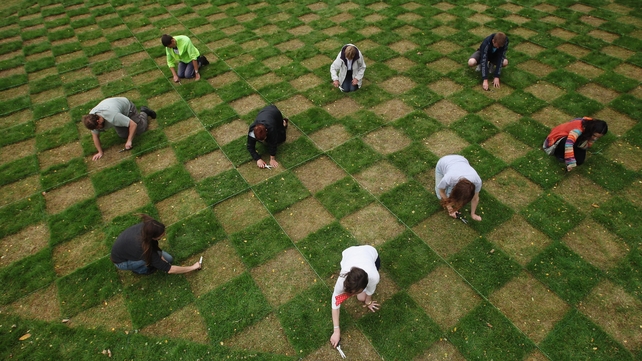 Volunteers cut a checkerboard design in the lawn at the National Trust's Ham House and Garden as part of an art project by Caroline Wright