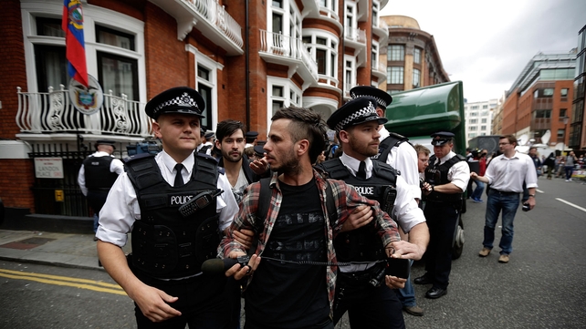 Police detain a supporter of Julian Assange during a protest outside the Ecuadorian embassy