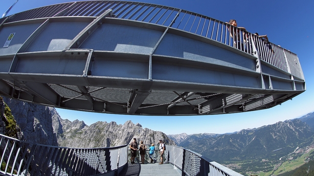 Tourists enjoy the view from the Alpspix viewing platform at the base of Alpspitze peak near Garmisch-Partenkirchen, Germany