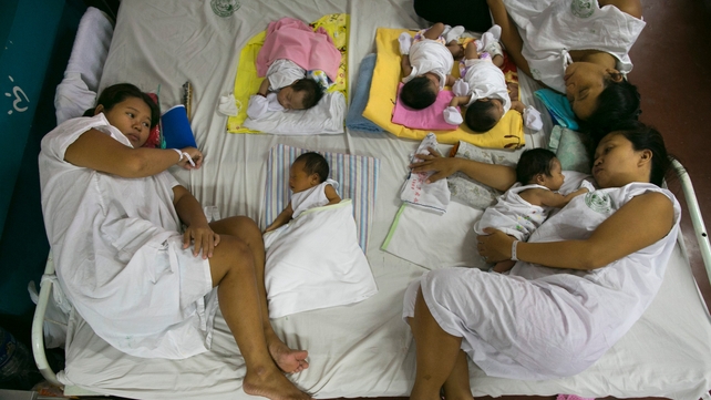 Mothers and their newborns share beds at an overcrowded hospital in Manila