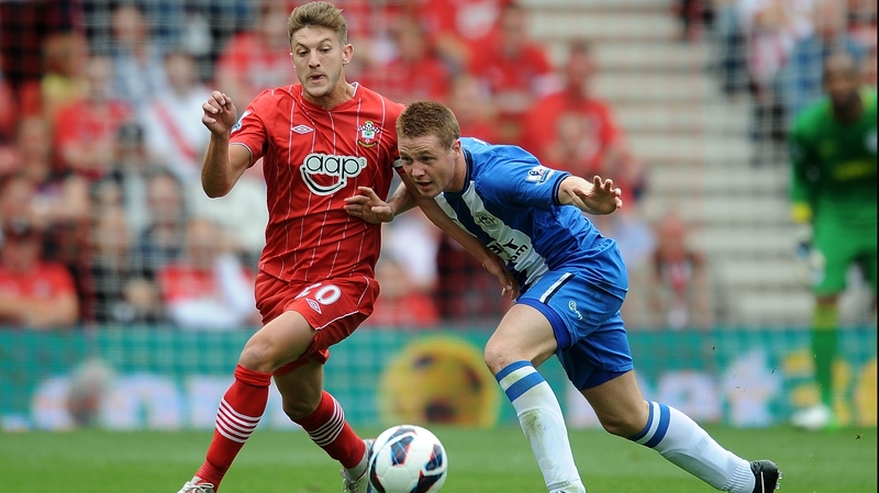 James McCarthy of Wigan tussles with Adam Lallana of Southampton