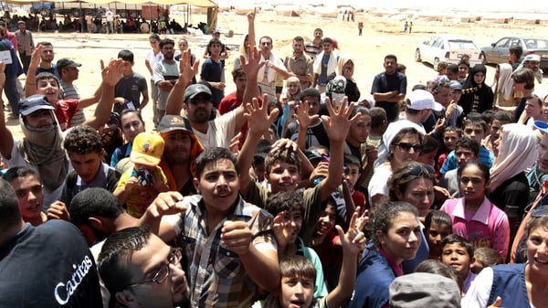 Syrian refugee children receive aid at the Zaatri refugee camp