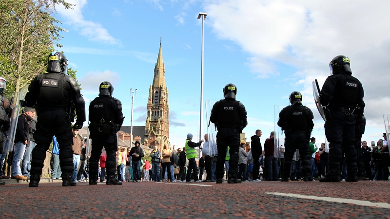 Police hold back nationalist protesters at a Royal Black Institution parade