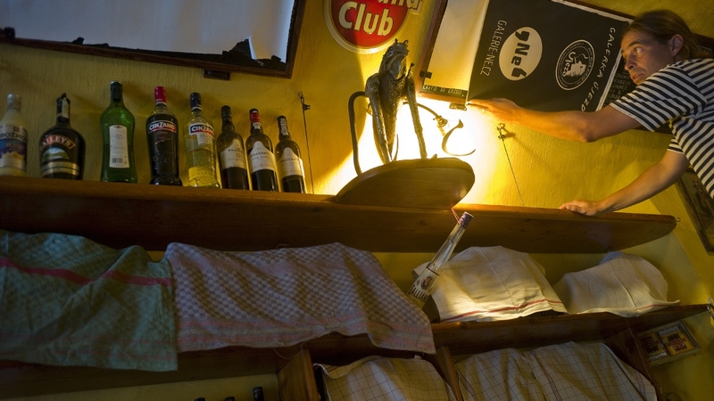 A barman covers a shelf of spirits following a government ban on drinks with an alcohol content over 20%