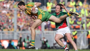 Rory Kavanagh bursts through the tackle of Alan Dillon