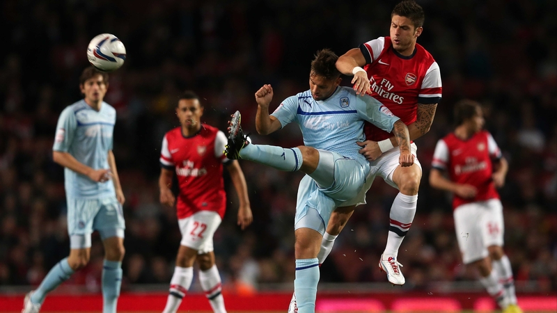 Olivier Giroud of Arsenal challenges Coventry's James Bailey