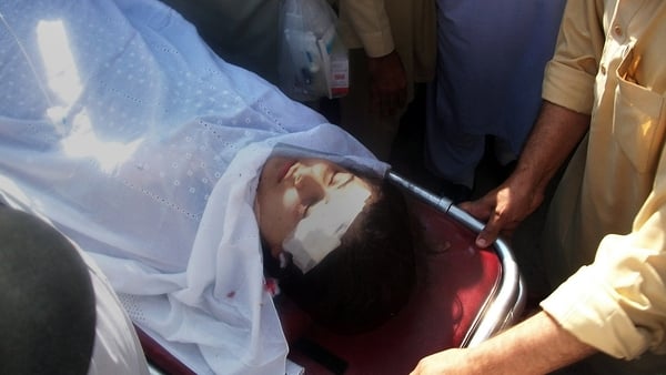 Pakistani hospital workers carry injured Malala Yousafzai, 14, on a stretcher at a hospital following an attack by gunmen in Mingora
