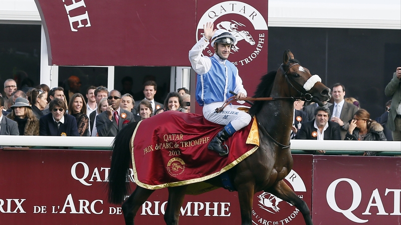 French jockey Olivier Peslier celebrates on Solemia after winning the Prix de l'Arc de Triomphe
