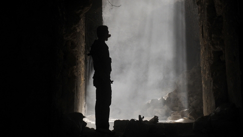 A Syrian rebel takes position during clashes with regime forces in Aleppo