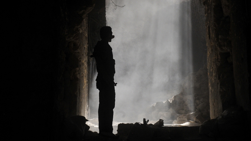 A Syrian rebel takes position during clashes with regime forces in Aleppo