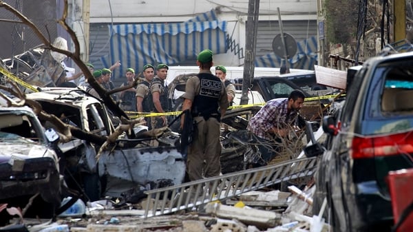 Police comb through the wreckage following yesterday's car bomb explosion in central Beirut