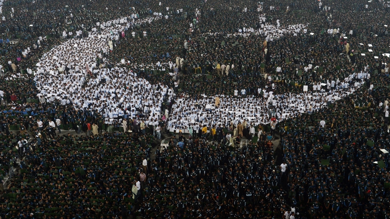 Pakistani youths make the biggest human national flag at the National Hockey Stadium in Lahore