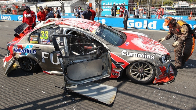 Ricky Taylor looks on after his Fujitsu Racing GRM Holden car lies on the track after a rollover in Australia