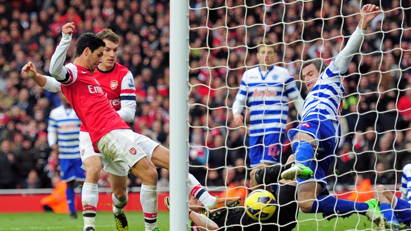 Arsenal's Mikel Arteta pokes the ball past Ryan Nelsen of QPR