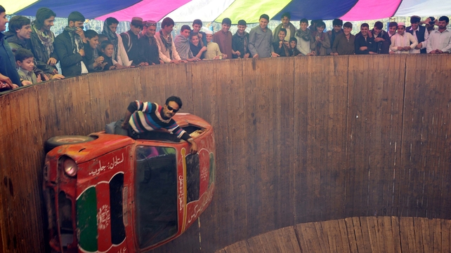 An Afghan circus performer drives a car on a 'Wall of Death' on the third day of Eid al-Adha in Jalalabad