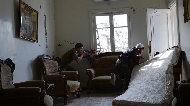 Rebel fighters take position in a flat in Aleppo during a battle against Syrian government forces