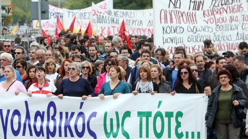 A sea of Greeks braved a steady downpour holding flags and banners standing before riot police guarding parliament.