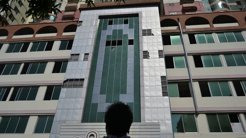 A man looks at the facade of Mandalay's highest building, the 25-storey Mann Myanmar Plaza, during this morning's earthquake