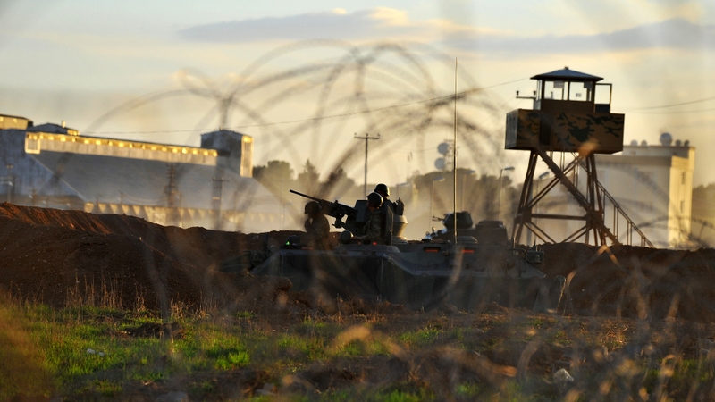 Turkish soldiers stand guard after Syrian aircraft bombed the strategic border town of Ras al-Ain