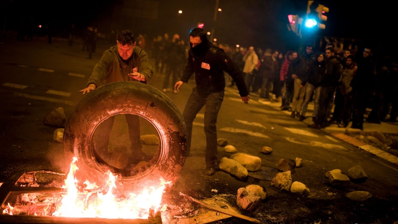 Demonstrators set up a barricade of burning tyres at the main entrance of the Mercabarna market in Barcelona