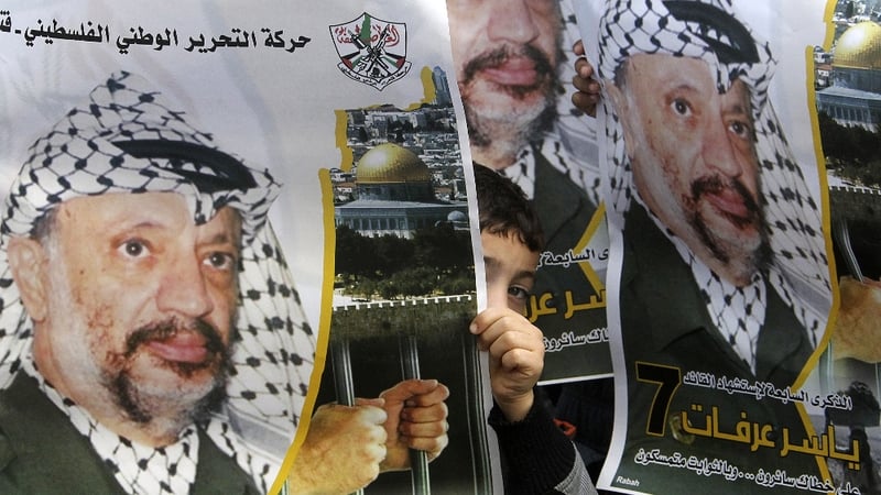 Palestinians hold up posters of former leader Yasser Arafat during ceremonies across the West Bank to mark the eighth anniversary of his death on 11 November 2012