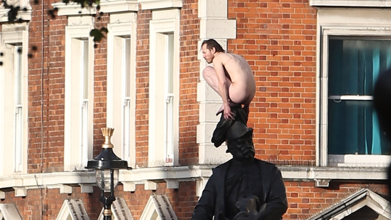 The naked man is believed to have been clothed when he climbed on to the statue