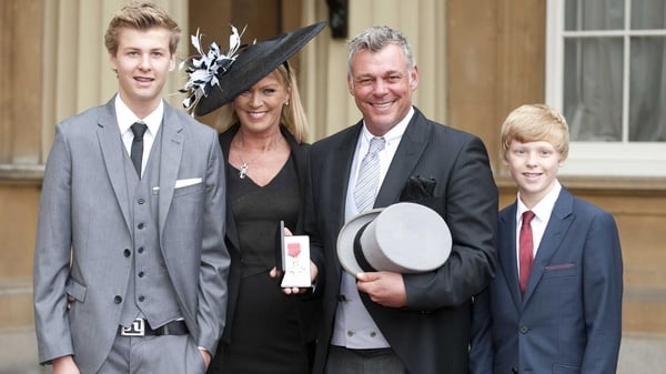 Darren Clarke and his family pose with his badge after receiving an OBE from the Queen