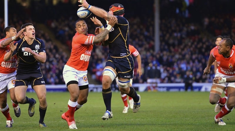 Alasdair Strokosch of Scotland tries to offload under pressure from Fetu'u Vainikolo of Tonga