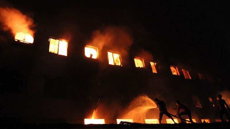 Bangladeshi people and firefighters trying to extinguish the fire