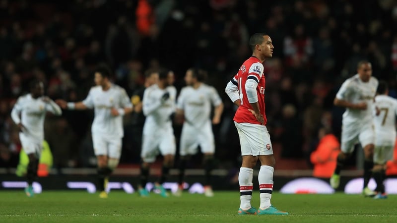 Theo Walcott turns away in disgust as the Swansea players celebrate Michu's first goal