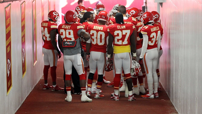 A sombre Kansas City Chiefs side huddle in prayer in the tunnel prior to their game with Carolina Panthers