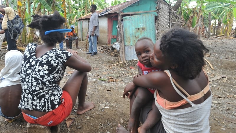 Haitians woman sits amid their destroyed home and banana grove 
in the Nippes section of Haiti following Hurricane Sandy